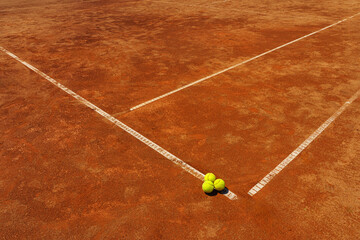  A yellow tennis balls lies on the clay court.