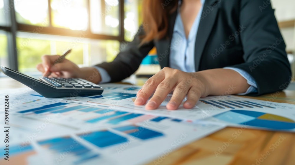Poster a woman is sitting at a desk with a calculator and a stack of papers