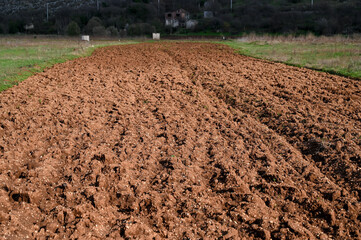 Freshly plowed field ready for seeding and planting in spring.  Brown soil.