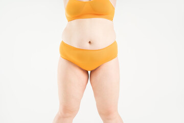 Tummy tuck, flabby skin on a fat belly, abdomen with obesity and cellulite, saggy stomach, plastic surgery concept on studio background