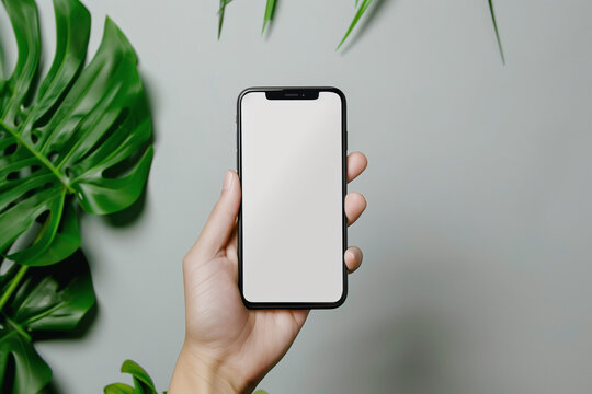 Close up person holding a phone with a mockup in hand on a simple background, a smartphone with a white screen to insert any image