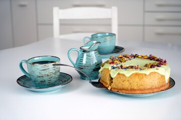 Ciasto, sernik, tort, pistacje z kawą na stole w kuchni