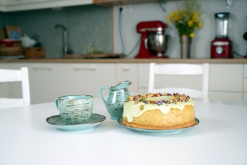 Ciasto, sernik, tort, pistacje z kawą na stole w kuchni
