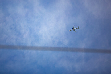 Airplane Flying High in Sky with Contrail