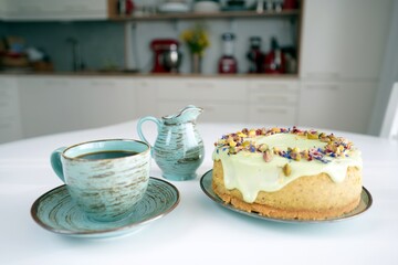 Ciasto, sernik, tort, pistacje z kawą na stole w kuchni