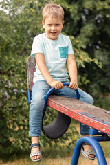 A happy child is happy to be lifted up with the help of a balance swing.