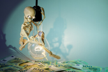 A funny and clever skeleton swinging on a light bulb, against a green background, campaigns to...