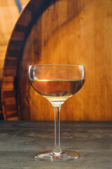 A glass of wine is sitting on a table next to a wooden barrel. Concept of relaxation and enjoyment
