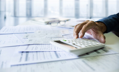 Close-up shot. accountant using calculator to calculate expenses and taxes from doing business to recive tax reduction for personal individual Income. tax return concept for individual person - obrazy, fototapety, plakaty