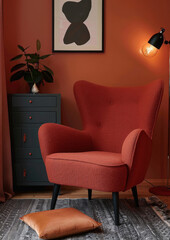 Relaxing red lounge armchair in modern retro interior living room. Dark orange colored walls. Interior design. Living space. Contemporary.