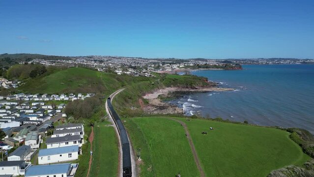 Waterside, Torbay, South Devon, England: DRONE VIEWS: A steam train on route to Paignton on the Torbay Steam Railway line. The steam trains are a major tourist attraction for UK holidaymakers (Clip 2)