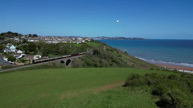 Broadsands, South Devon, England: DRONE VIEWS: A steam train on route to Paignton on the Torbay Steam Railway line. The steam trains are a major tourist attraction for UK holidaymakers.