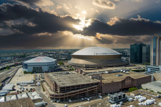 aerial shot of the Caesars Superdome and the Smoothie King Center with skyscrapers, office buildings and hotels in the city skyline and cars on the street in New Orleans Louisiana USA