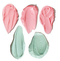 Green and pink smears of cream on empty background