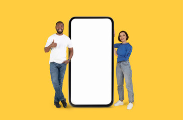 Man and woman standing by giant smartphone
