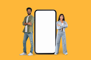 Two people next to a large smartphone mock