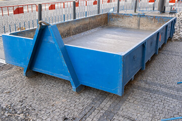 Empty blue waste container A steel industrial with on the street, urban communications construction...