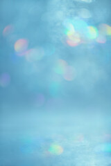 abstract light, blue background with multi-colored, rainbow highlights and bokeh