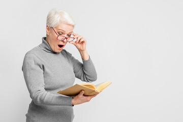 Senior woman engrossed in reading a book