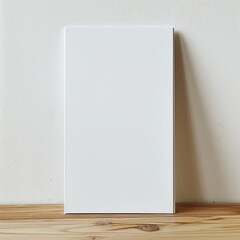 A blank canvas stands on a wooden table against a beige wall in the background.
