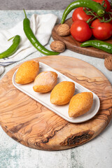 Uncooked frozen stuffed meatballs. Kibbeh or kibbeh on a wooden serving board