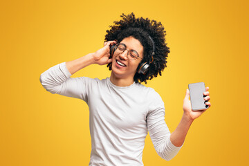 Handsome young man in headphones listening to music on phone