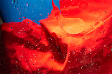 a close up of a red and blue liquid with bubbles in it