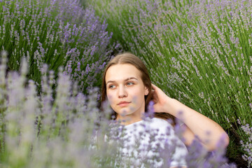 A young woman happily laying in a field of lavender flowers