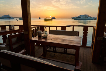 Rest by the red sea at dawn. Romantic breakfast in a cafe