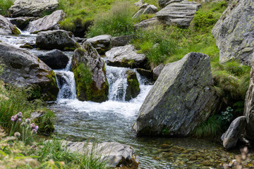 Waterfall amidst rocks and grass in a natural landscape