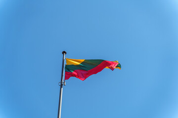 Lithuanian national flag waving on blue sky background. Republic of Lithuania, LT