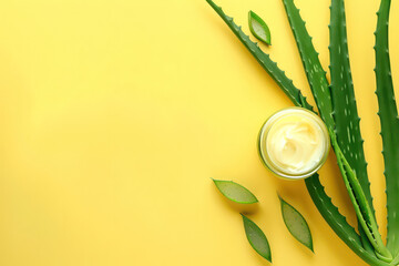 Jar with cream and cut aloe leaves on yellow background. Flat lay. Empty advertising banner template for cosmetics