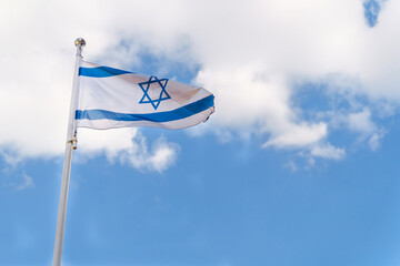 Flag of Israel The national flag of the State of Israel on blue sky background with white clouds
