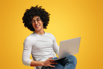 Cheerful african american guy watching webinar on laptop