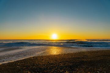 Au bord de l'océan Atlantique, dans la baie d'Audierne en Bretagne, un coucher de soleil teinte le...