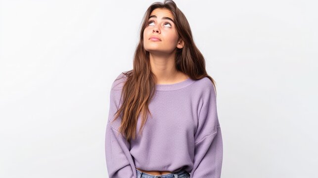 Young woman in a purple sweater looking upwards, embodying hope and aspiration, Concept of dreaming and optimism in contemporary youth
