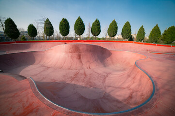 Empty public pink skate park waiting for skaters. Skateboard in city. Skate and Bike Park. Extreme sports ground	
