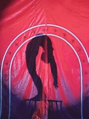 Circus acrobat silhouette showcasing astonishing contortion and  balancing act on the table amidst...