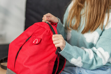 Morning preparation before school. Close Up of Red Backpack and Children's Hands. Back to school.