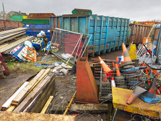 Junk yard and steel container with scrap metal, wood and traffic cones