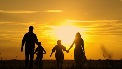 Dad, Mom teaches children to ride bike, sunset. Childhood dream of riding bike. Family walk, mom...