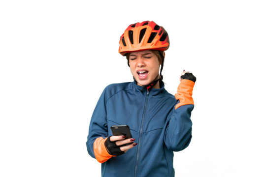 Young cyclist girl over isolated chroma key background with phone in victory position