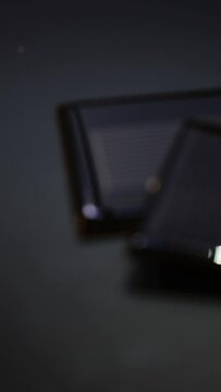 Shot of two photovoltaic solar panels placed on a dark surface. The image is gradually focused and defocused.