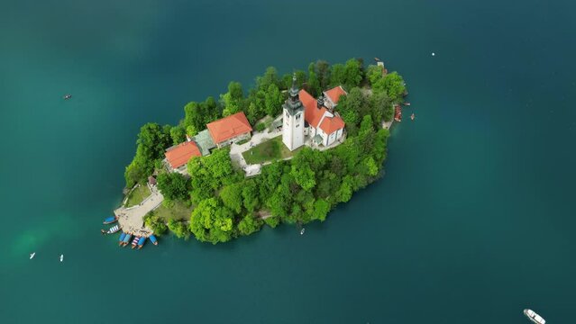 Aerial top around view Pilgrimage Church of the Assumption of Maria on a small island, Bled lake, Slovenia, 4k