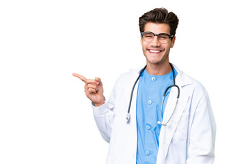 Young doctor man over isolated background pointing finger to the side