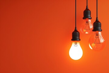 3 LED light bulbs of different sizes and shapes hanging on the orange background - obrazy, fototapety, plakaty