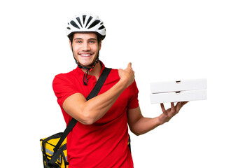 Pizza delivery man with work uniform picking up pizza boxes over isolated background pointing back