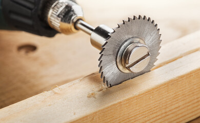 circular saw for milling machine cutting hole in wooden plank.