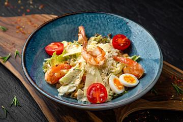Tender salad with iceberg, shrimp, parmesan and quail eggs. Menu for a pub on a dark background. Colorful juicy food photography.