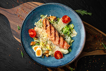 Tender salad with iceberg and grilled salmon fillet. Menu for a pub on a dark background. Colorful juicy food photography.